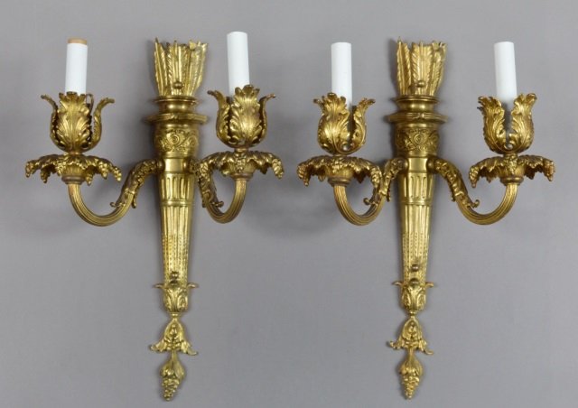 Pair of French Louis XVI Style Gilt Bronze Sconces: Gilded bronze two arm sconces with arrow and quiver motif. Height 17 inches, width 12 inches.