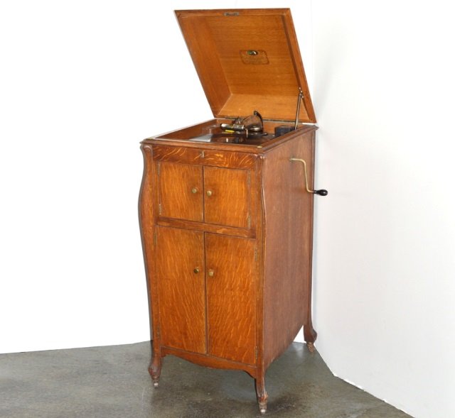 Vintage Oak RCA Victrola: Made by the Victor Talking Machine Co. Camden, NJ. Includes large collection of vintage records. Height 44 inches, width 20 inches, depth 22 inches.
