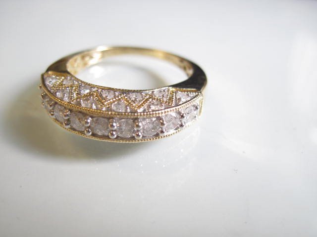 14K Diamond Band: A contemporary 14K yellow gold and diamond anniversary band. There are nine full cut 6-8 point diamonds across the top for a total carat weight of approximately .63 carats and 22 1-1/2mm single cut si