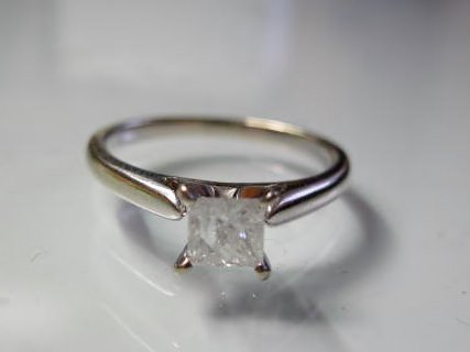 14K Diamond Solitaire Ring: A 14K white gold ring containing an approximately .50 carat princess cut diamond. Diamond is whitish with inclusions. Finger size 7. Weight 2.8 grams.