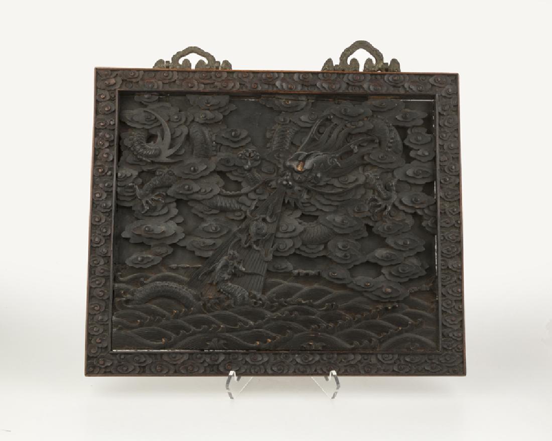 A Chinese carved wood panel: 19th century Carved teak, dragons among clouds and in the sea 15.875" H x 19" W x 1.25" D Provenance: Private Collection, San Diego, CA.