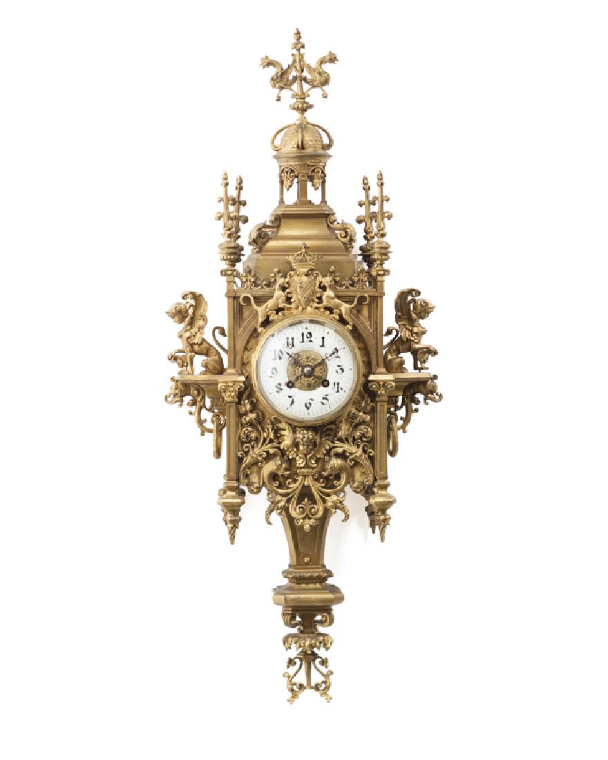 A German gilt-bronze Gothic-style cartel clock: Late 19th/early 20th century Movement signed: C.CH / 990 4.8, face with rubbed marks: *Bredea** / ** Luminea**S* Surmounted by a double-griffin finial atop a domed pavilion, the elaborately foliate mo