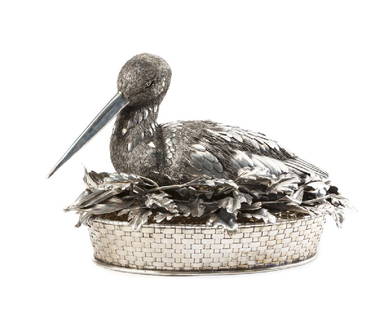 A Buccellati .800 silver bird-form centerpiece basket: 20th century Signed to leaf and basket: Mario Buccellati, further marked: 800 Modeled as a nesting stork with molded and chased feathers and small-gauge wire down, raised on an oblong basket 10.375" H