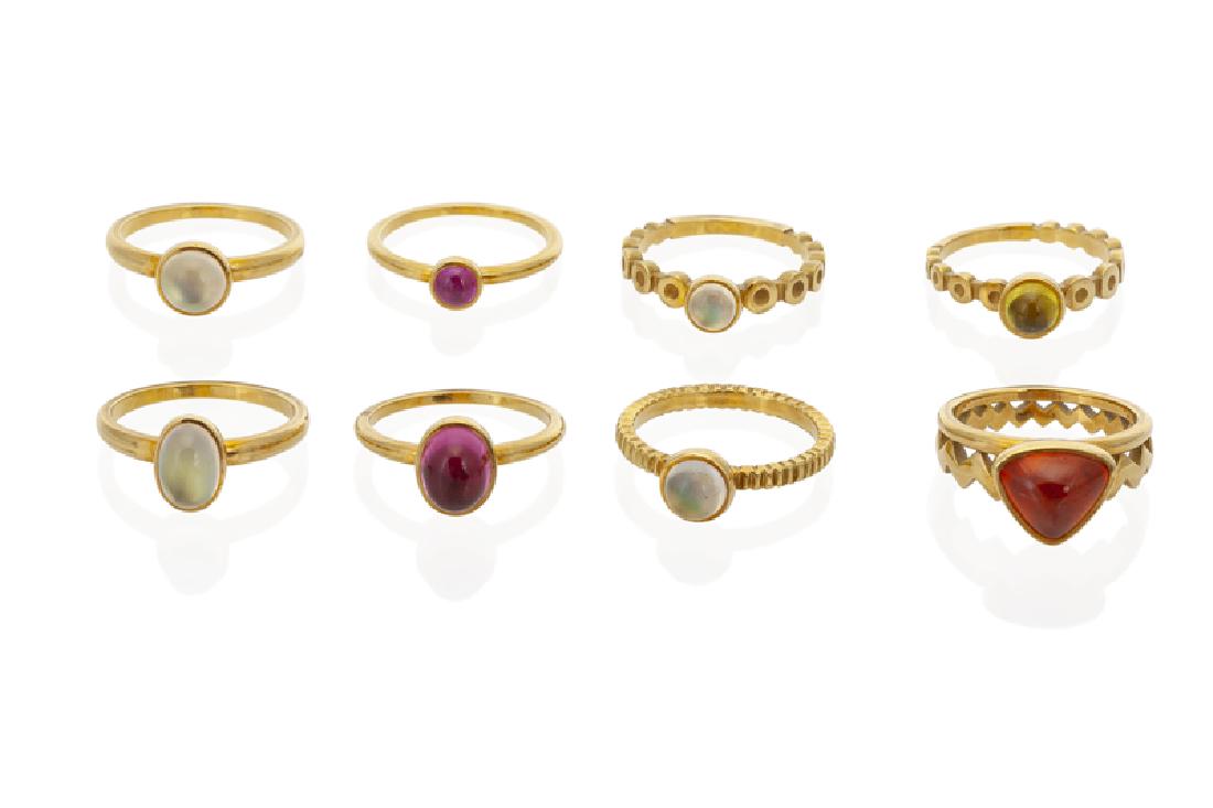 A group of cabochon gemstone and gold rings: 18K yellow gold The stackable rings set with moonstones, tourmaline, and peridot and come in various motifs Ring sizes: 7.5-8 34.26 grams gross 8 pieces Provenance: The Estate of Georgia Hollinger Cla