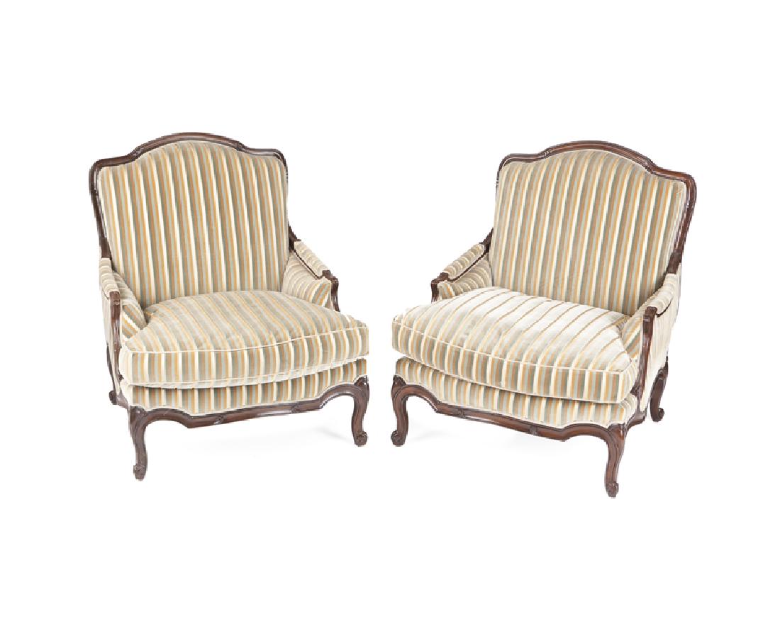 A pair of French Provincial-style bergeres: Contemporary Each carved frame with striped velvet upholstery, on cabriole legs, 2 pieces Each: 38.5" H x 27.5" W x 33" D Provenance: Private Collection, Beverly Hills, CA.