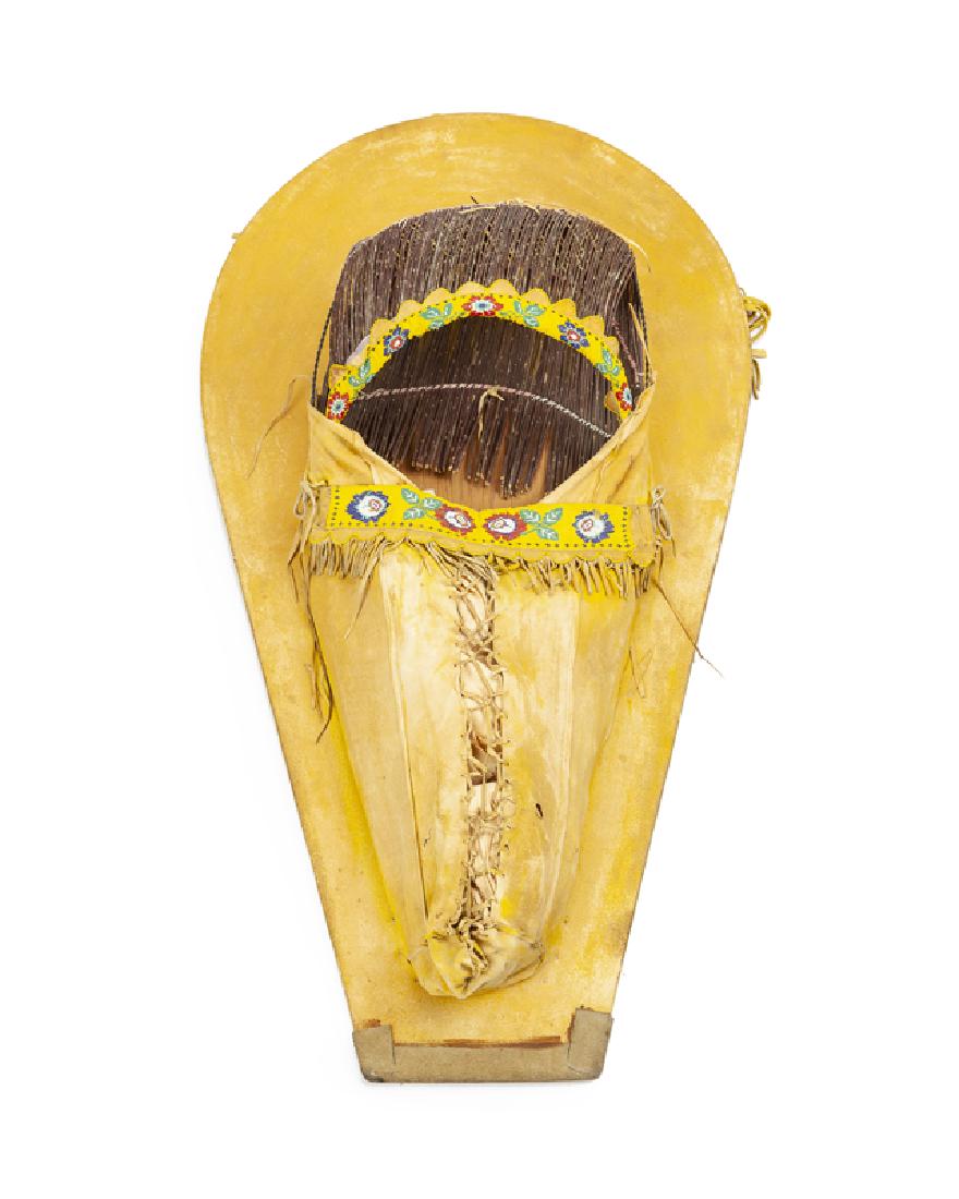 A Shoshone/Blackfoot beaded hide baby carrier: Third quarter 20th century With rose-motif yellow-ground beadwork and leather fringe 43" H x 23.25" W x 10" D Provenance: The Towaoc Trading Post Collection, Ute Mountain Ute, Towaoc, Colorado.