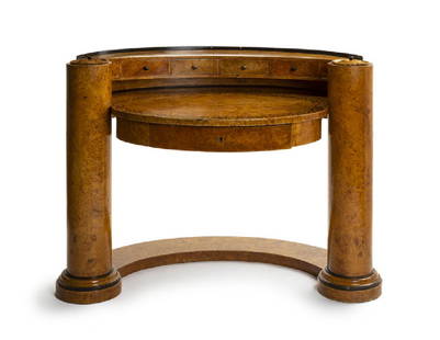 A Biedermeier-style birds eye maple desk: Late 19th century After Josef Danhauser, burr ash and ebonized wood, the curved top fitted with six short drawers and two lidded compartments, over an oval writing surface with scrolling foliate marqu