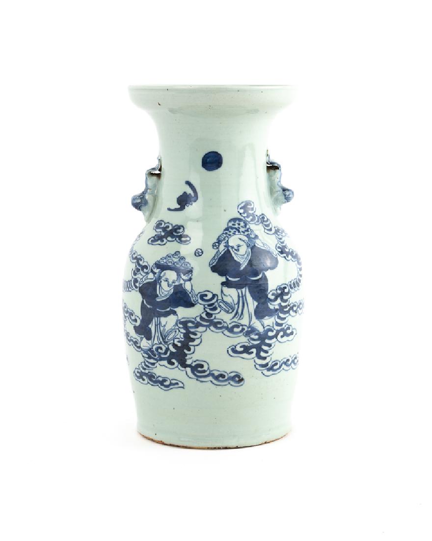A Chinese blue and white glazed porcelain vase: Late 19th/early 20th century Decorated with blue figures on a white ground flanked by animal-form handles 13.375" H x 6.75" Dia.