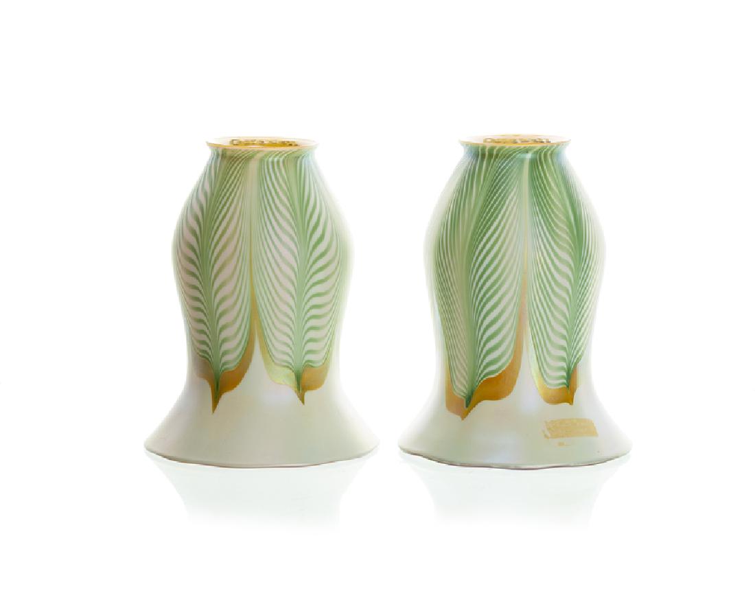 A pair of Quezal art glass trumpet-form shades: 20th century Each signed to fitter rim: Quezal Each of green and gold feathered design on a white ground with gold iridescent interior, 2 pieces Each: 6" H x 4.5" Dia. Provenance: The Estate of Harry 