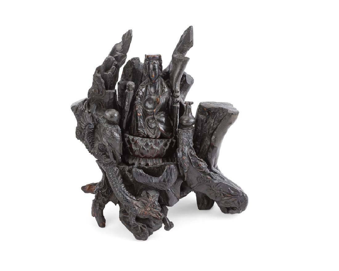 A Chinese carved wood figural group: 20th century Ebonized wood, Guanyin raised on an elaborate throne 10.125" H x 9" W x 6.25" D Provenance: Estate, Santa Monica, CA.