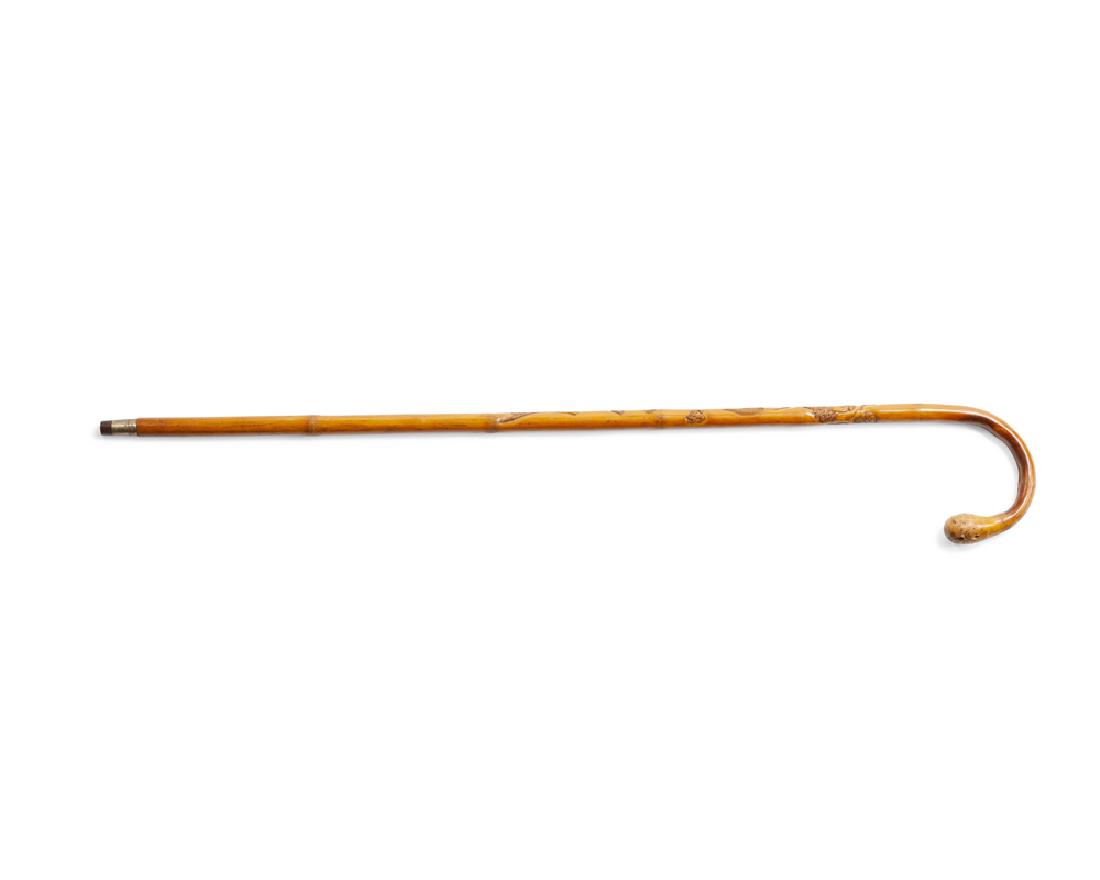 A Chinese carved bamboo cane: Late 19th century Carved to stick: House of Shuilin / Lush Mountain Sword / [artist's signature] Curved bamboo with carved dragon to staff terminating in a brass and metal cap 36" L Provenance: Privat