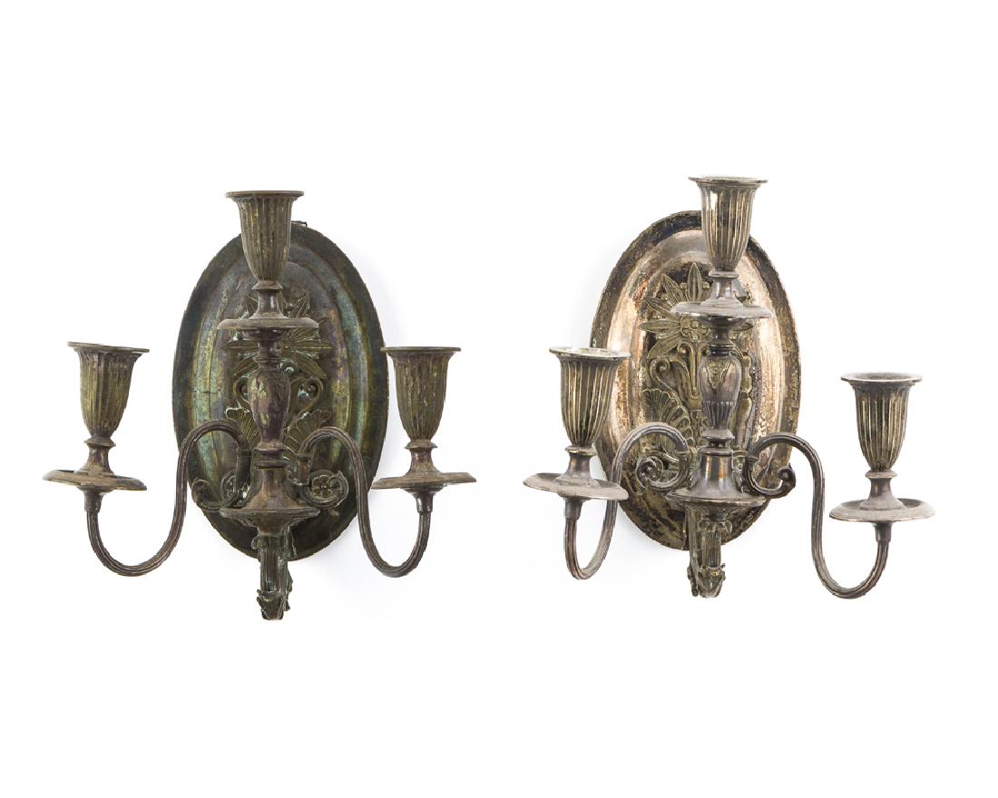 A pair of silver plate wall sconces: Late 19th/early 20th century Each oval wall plaque issuing a three-light candle holder, 2 pieces Each: 10.75" H x 10.5" W x 9" D