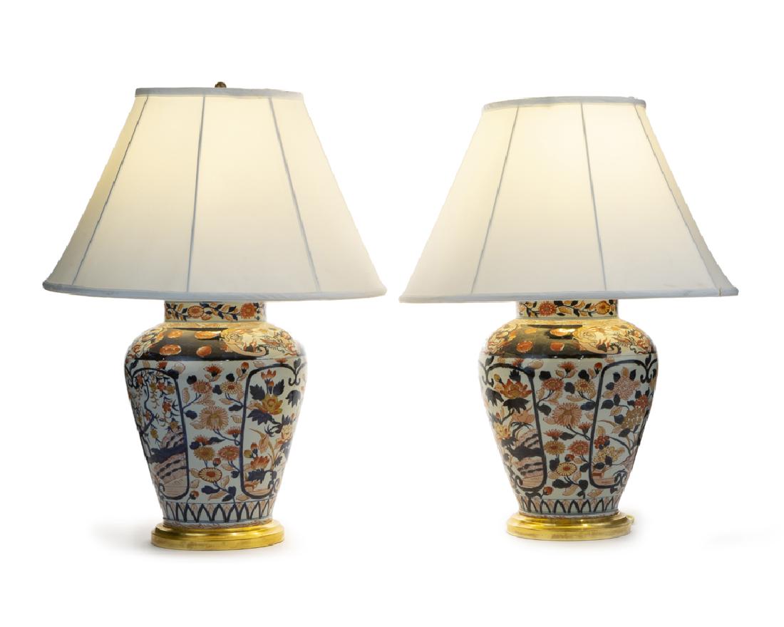 A pair of Imari porcelain lamps white linen shades: Second half 20th century Each single-light lamp over a polychrome baluster-form base with a later-added white linen shade, 2 pieces Each: 29.25" H x 21" Dia.