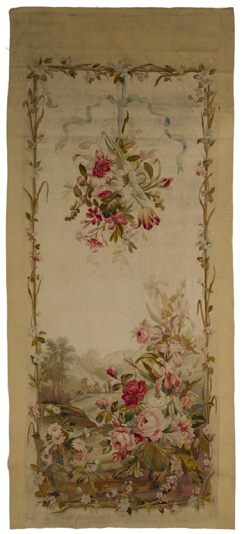 An Aubusson floral tapestry panel: Second half 19th century Unsigned Designed with a floral garland border suspending a bouquet of flowers from a blue ribbon over a flower bunch in a mountainous landscape 106" H x 47.25" W