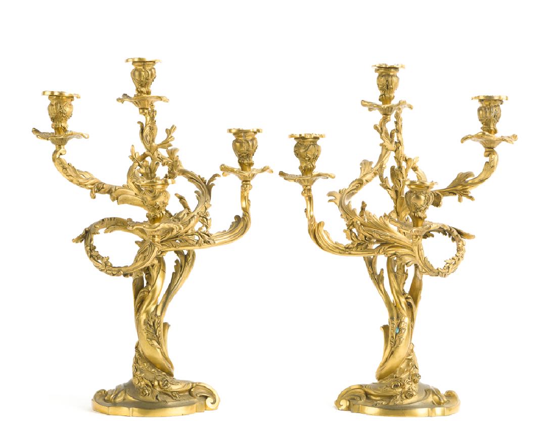 A pair of Louis XVI-style gilt-bronze candelabra: Each four-light candelabrum with scrolled arms issuing from a rocaille standard and base adorned with leaves and roses, 2 pieces Each: 20" H x 13.75" W x 11.75" D
