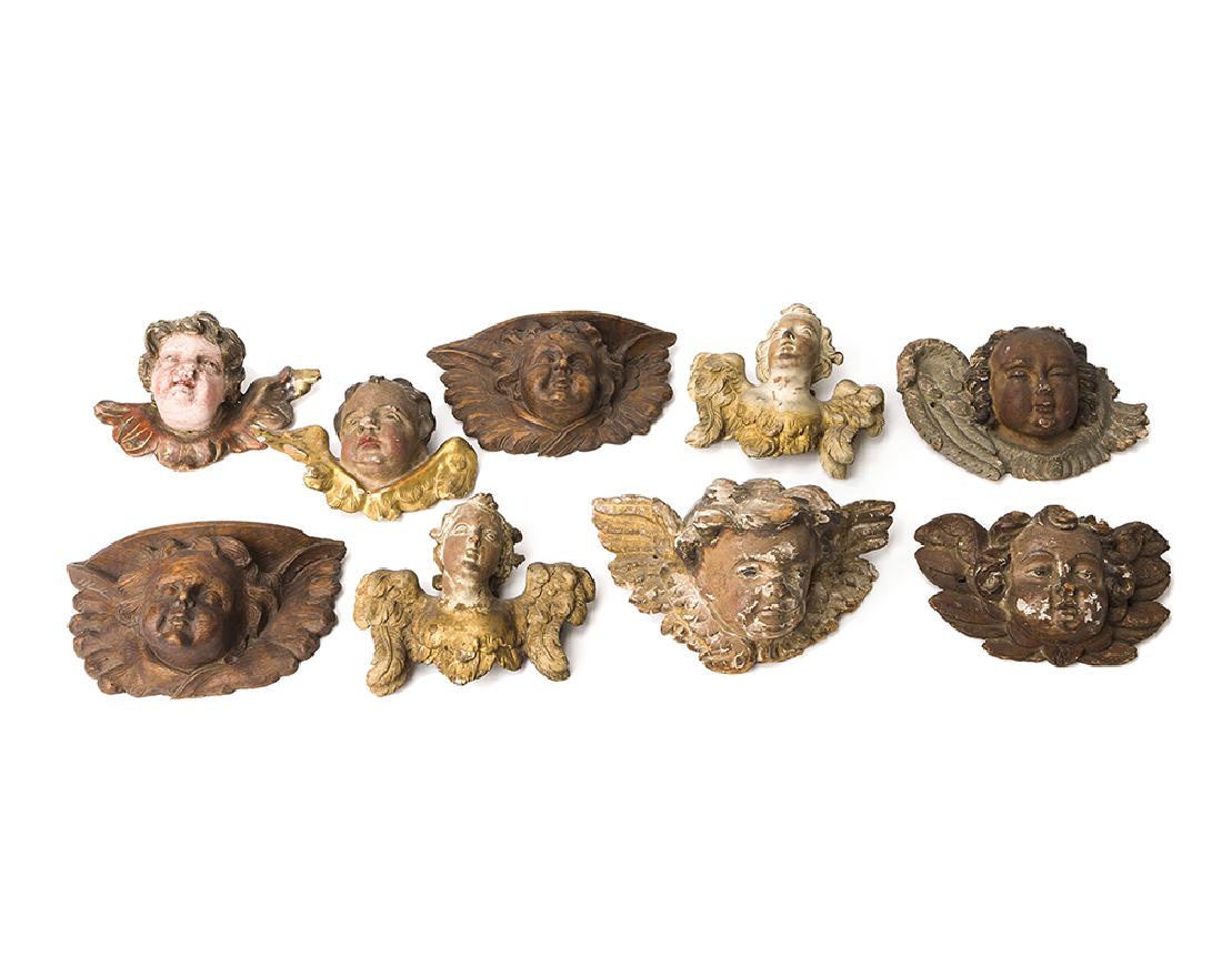 Nine German carved wood cherub heads: 17th-19th century Each carved cherub with wings, all but two decorated with polychrome paint and gilt highlights, 9 pieces Largest: 6" H x 11.25" W x 5.625" D