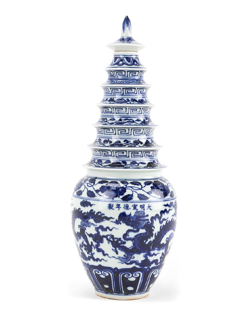 A Chinese blue and white lidded bottle: 20th century The widening neck in a stepped pagoda motif over a baluster-form body adorned with geometric bands and scenes of dragons 16.25" H x 5.75" Dia.