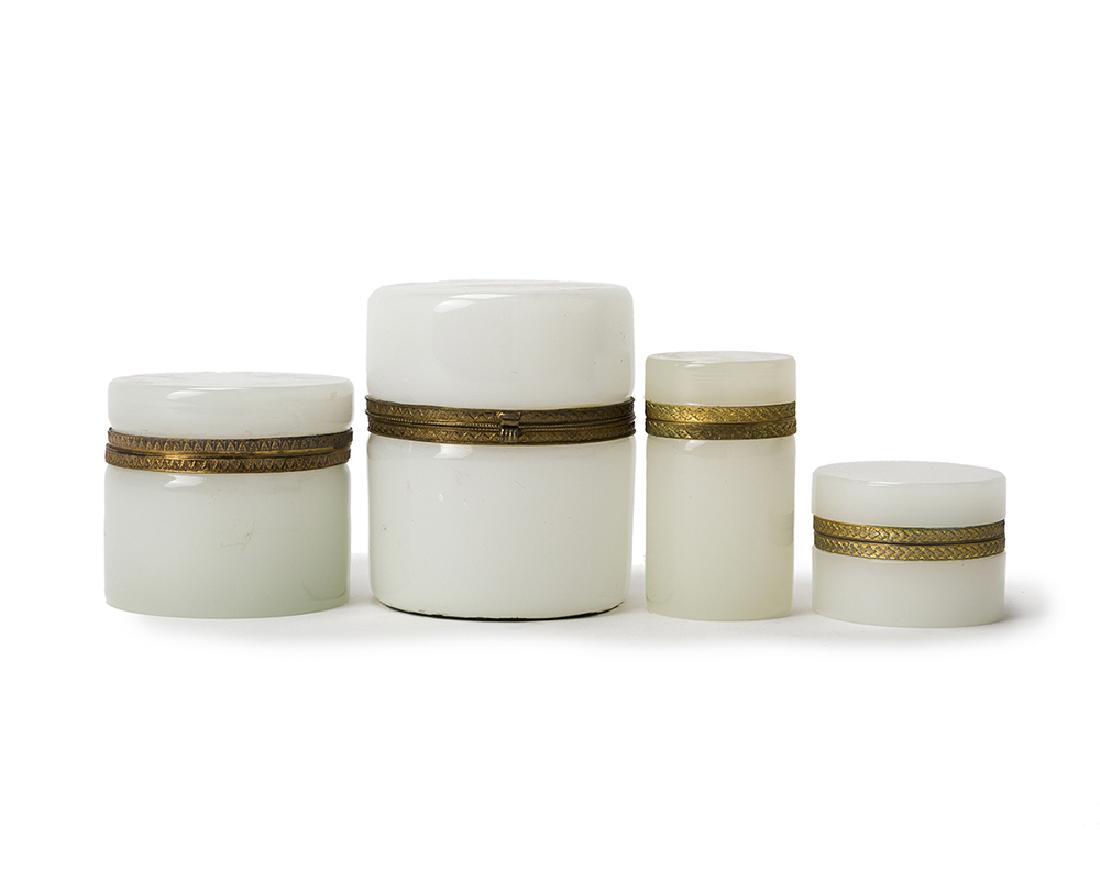 Four white opaline glass vanity boxes: 20th century Each circular lidded box with gilt bronze mounts, 4 pieces Largest: 5" H x 4.125" Dia.