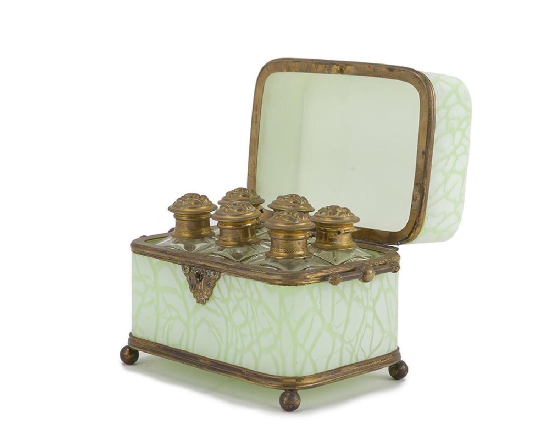 A cased opaline glass vanity box: First quarter 20th century The green and white lidded box enclosing six jars set with gilt metal mounts 5" H x 6.5" W x 4.25" D