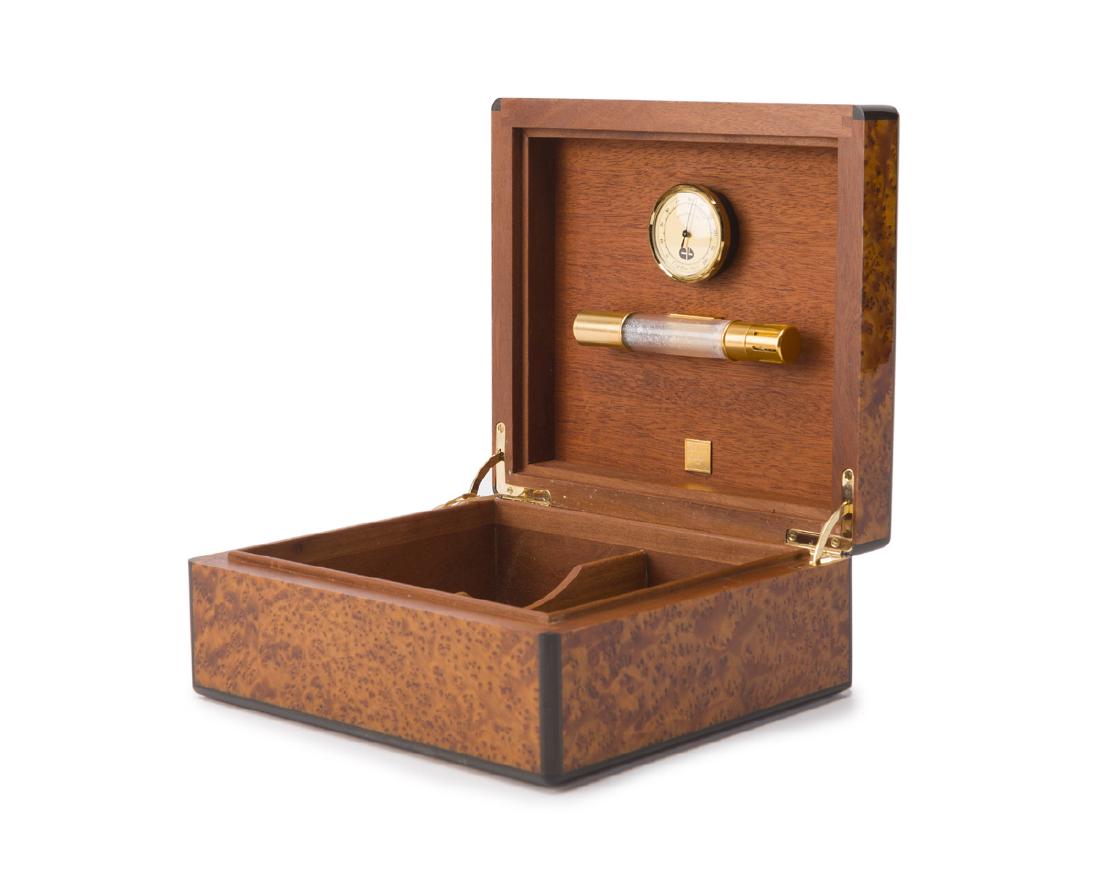 An Elie Bleu humidor: With metal tag to lid Box table model, the burlwood veneered box enclosing a divided compartment 4.125" H x 9.75" W x 8.75" D