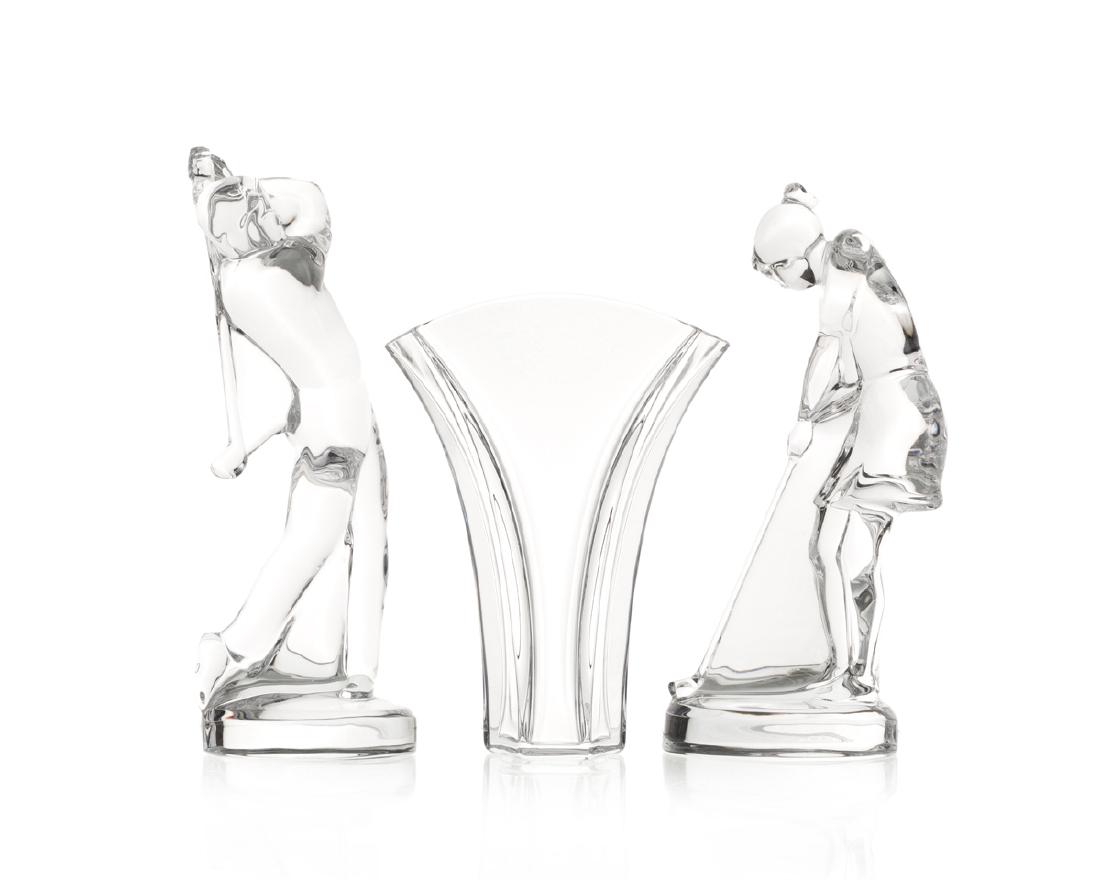 Three Baccarat decorative items: Second half 20th century Each signed: Baccarat France Comprising a male golfer figurine designed by Bernard August, a female golfer figurine, and a gingko vase, each in original box, 2 pieces Largest: