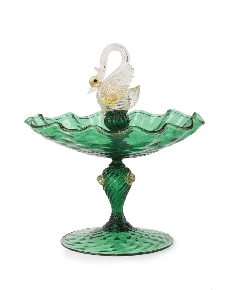 A Salviati swan-motif centerpiece: Third quarter 20th century The clear and gold glass swan over a green pedestal dish 9" H x 8" W x 7" D