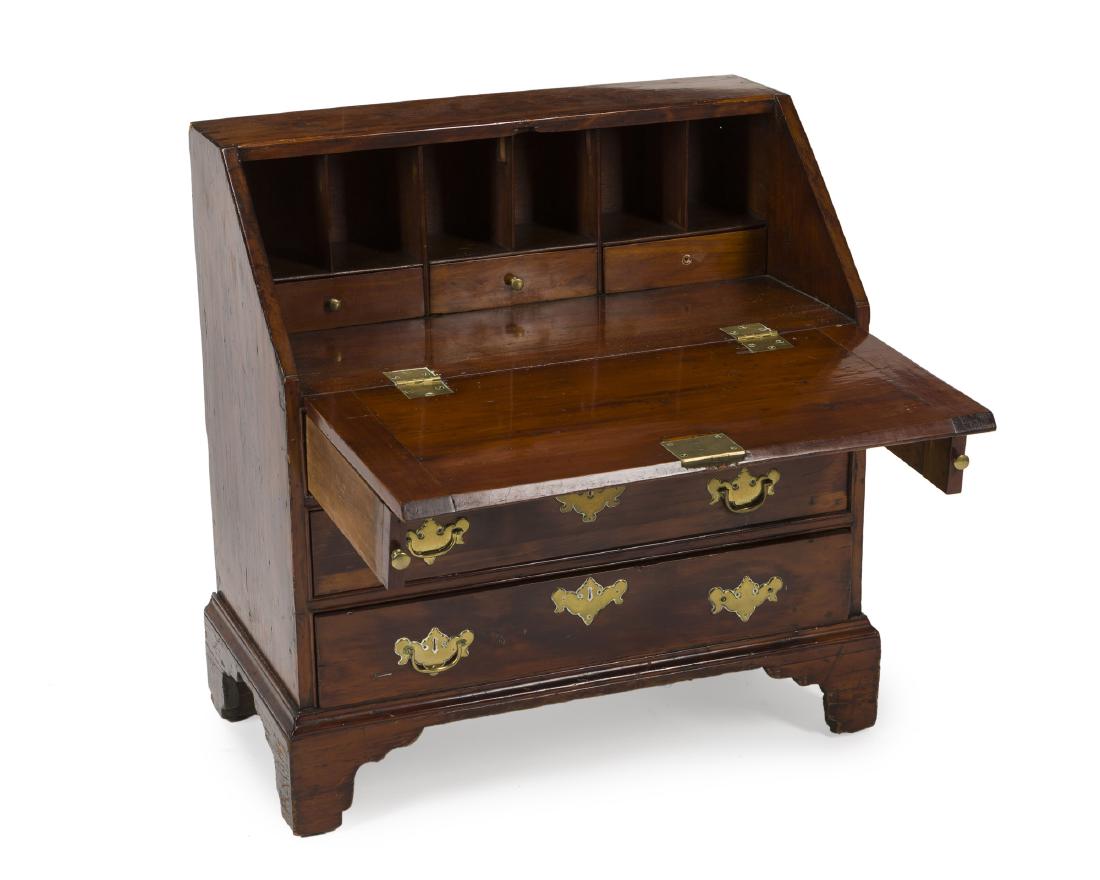 A diminutive desk: 19th century The hinged top enclosing a writing surface, six pigeon holes, and three drawers over three long drawers raised on bracket feet, pine secondary wood 25.625" H x 25.5" W x 13.5" D