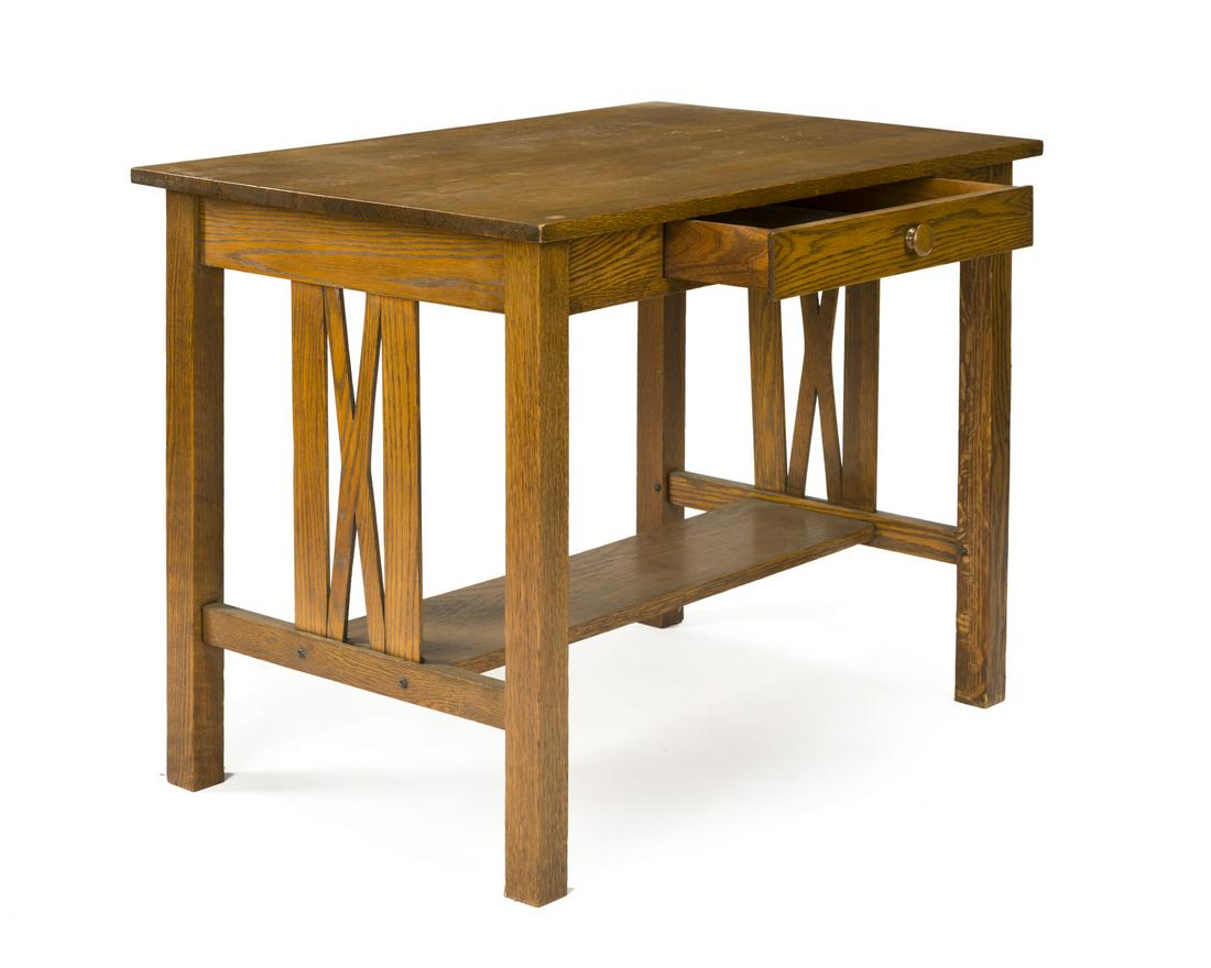 An Arts & Crafts-style oak desk: 20th century The rectangular top over single drawer raised on post legs with a rectangular stretcher 29" H x 36" W x 24.25" D