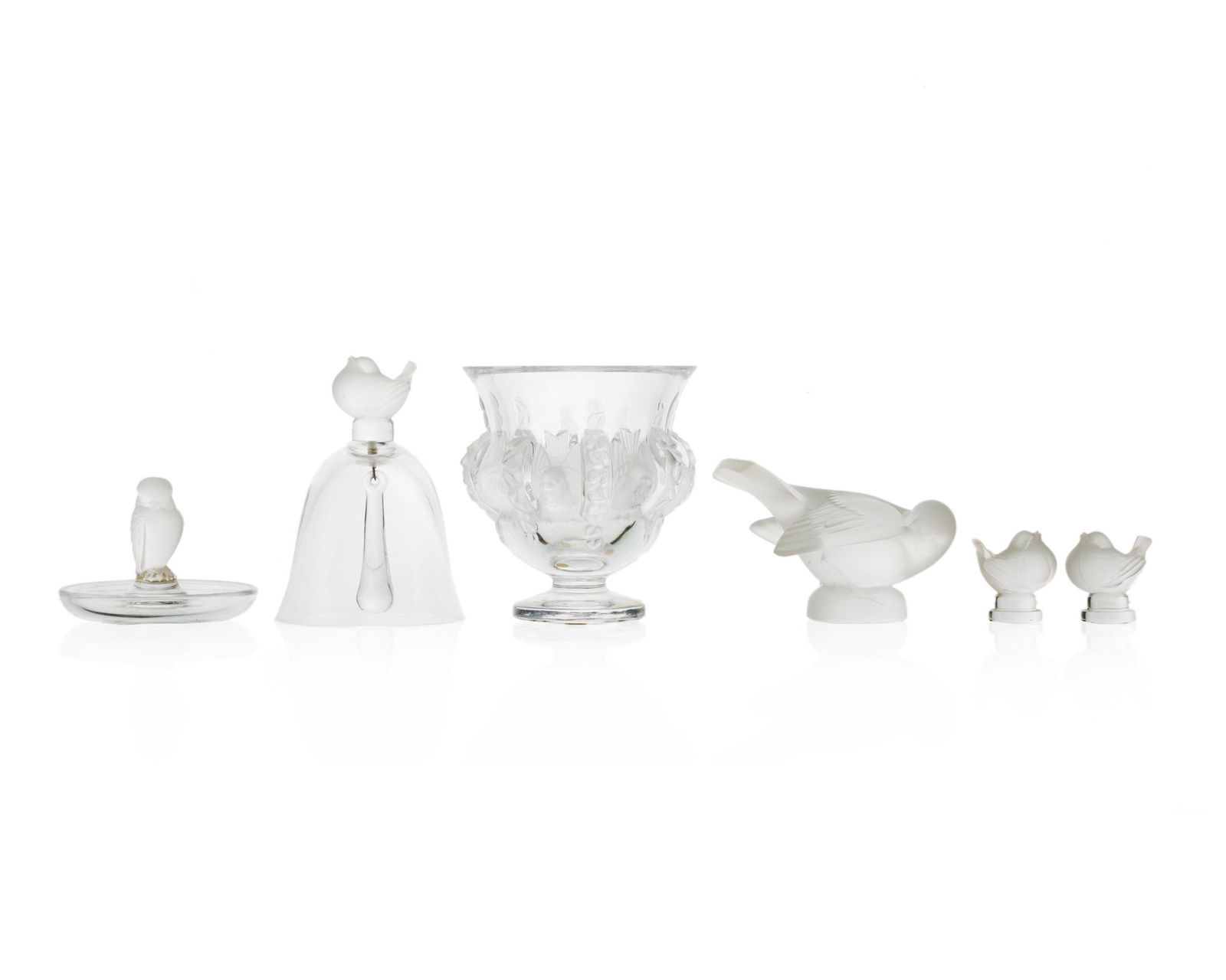 Six Lalique objets d'art: Second half 20th century Each with acid-etched signature: Lalique France Comprising a "Rapace" ring holder, a finch dinner bell, two finch figurines, a dove figurine, and a "Dampierre" vase, 6 piece