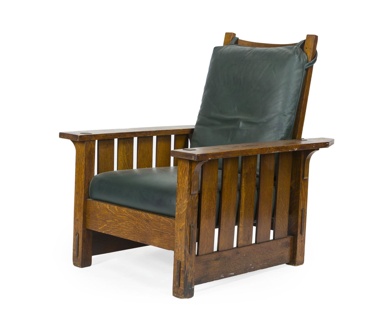 A Gustave Stickley Morris chair, No. 2342: First quarter 20th century Apparently unsigned The ladder back fitted with a green leather backrest issuing rectangular arms over a leather cushion raised on post legs joined by a rectangular stretc