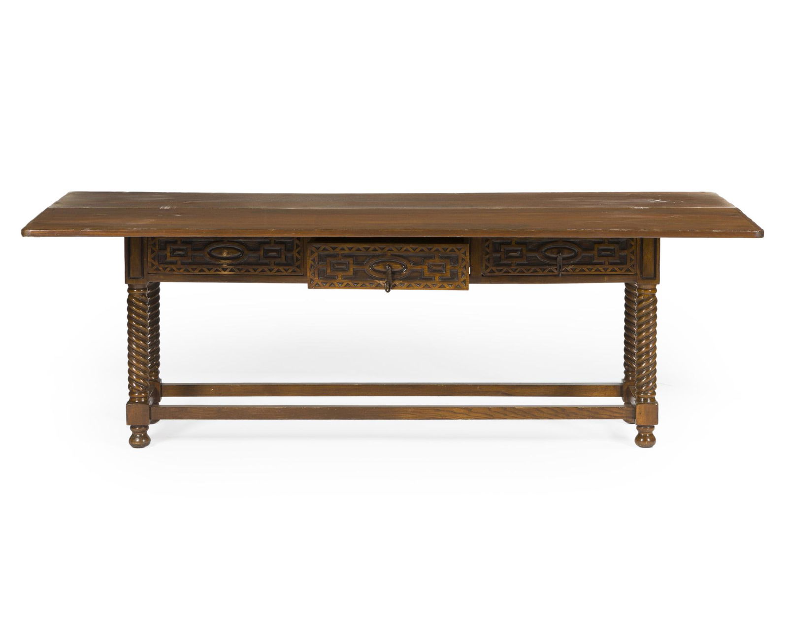 A Spanish Revival flip-top console table: Third quarter 20th century Hinged rectangular top over three short carved drawers, set into a conformingly decorated apron and raised on twisted legs on bun feet, joined by a rectangular stretcher 2