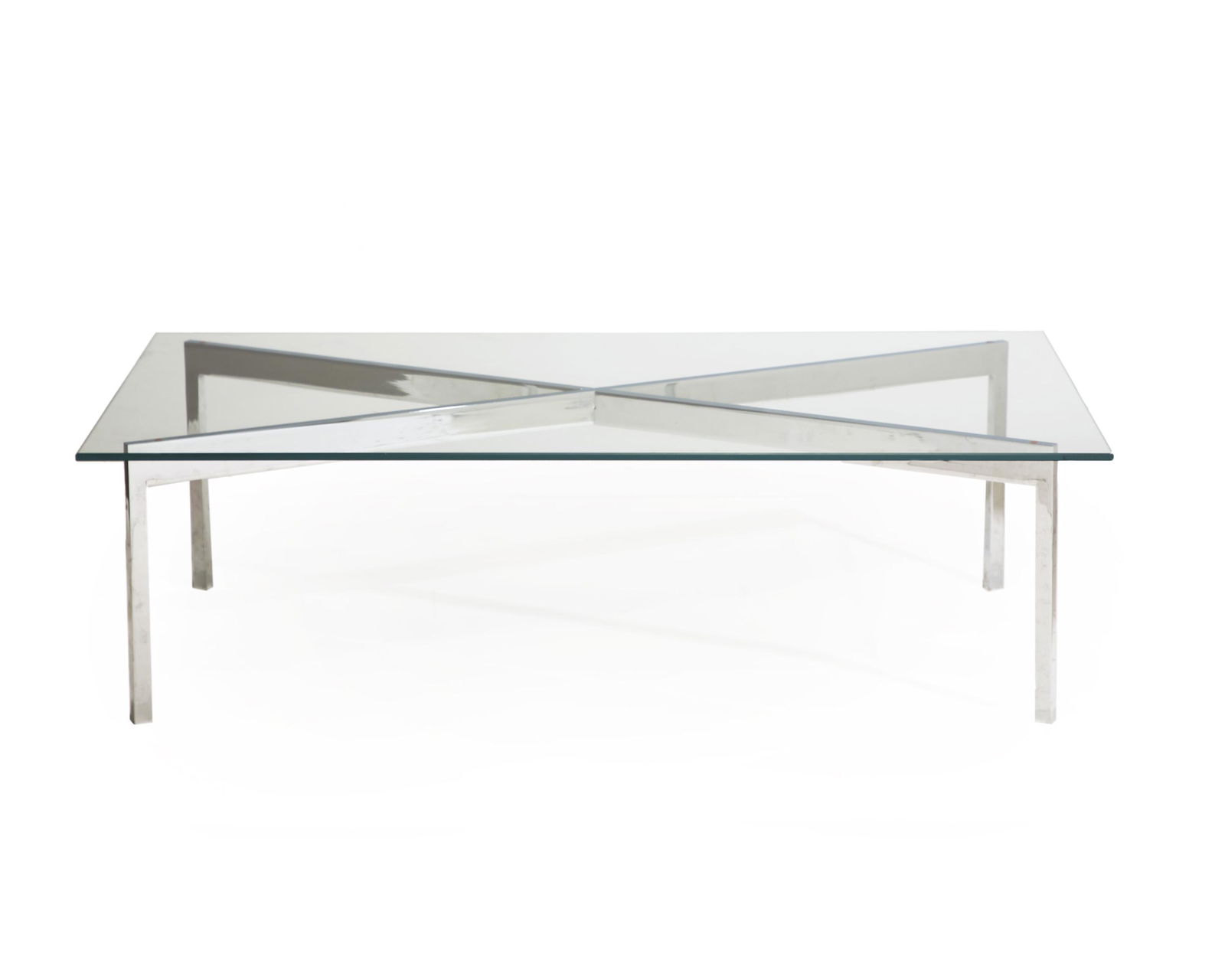 A chrome and glass cocktail table: Third quarter 20th century Attributed to Gerald McCabe for Eon Furniture, the rectangular glass top on an X-form chromed metal base 15.5" H x 53.625" W x 30" D