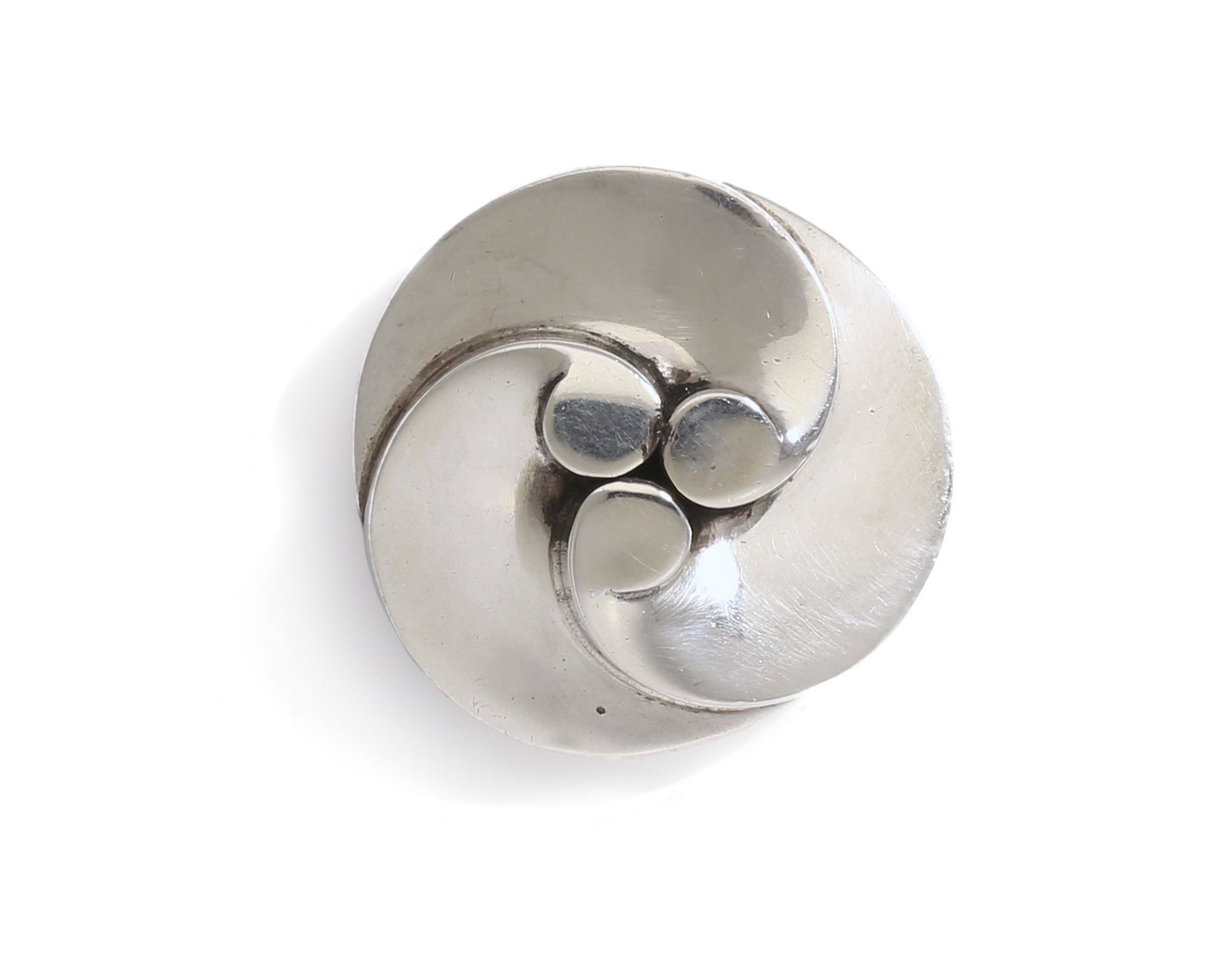 An Antonio Pineda "Three Waves" silver brooch: 1953-1978 Crown mark for Antonio Pineda; Eagle 17; Further stamped: Taxco Mexico / Kirk / Silver Silver brooch made to resemble three overlapping waves 1.75" Dia. 37.5 grams Provenance: The Colle