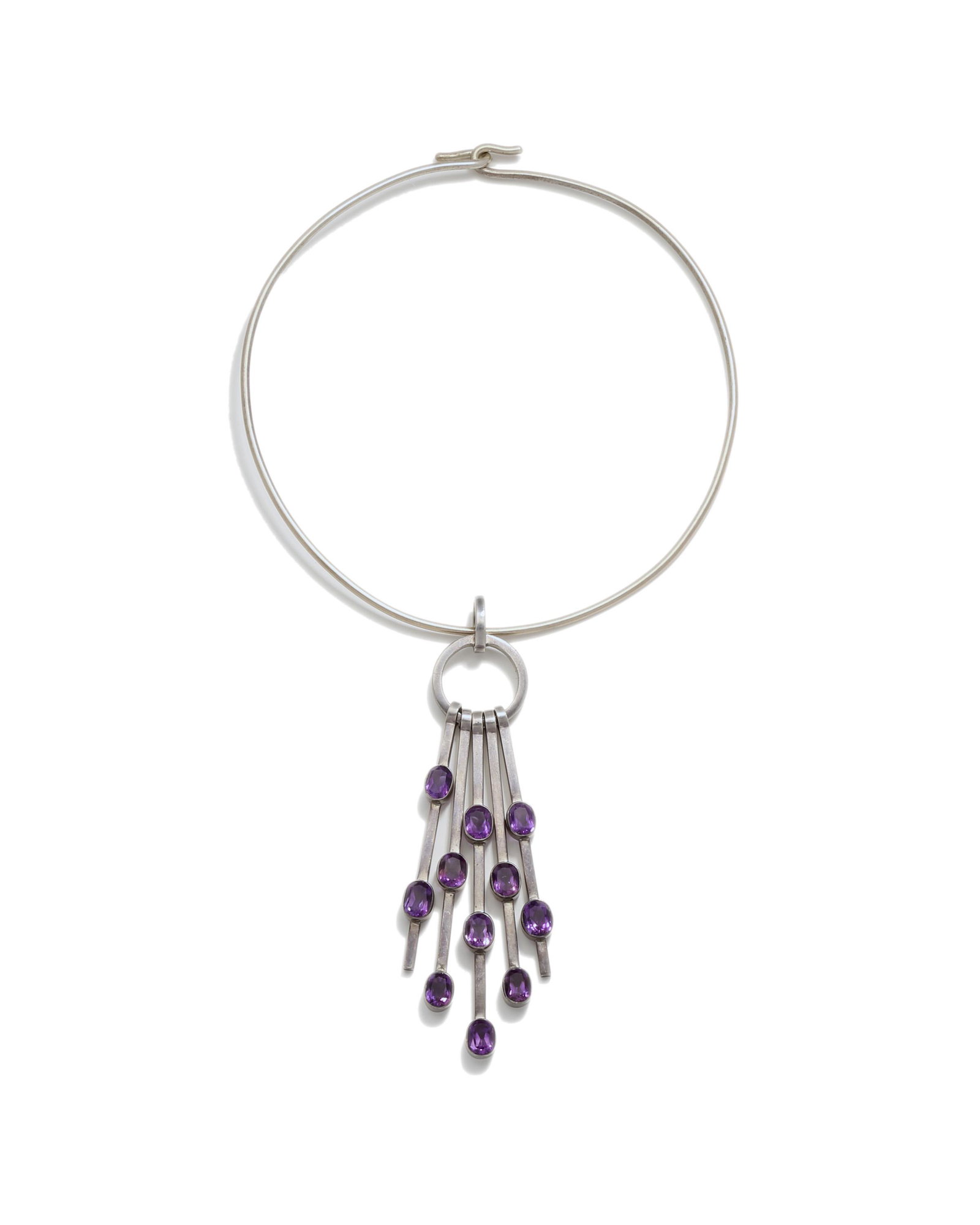 A Carmen Beckmann sterling silver and amethyst collar: Third quarter 20th century Pendant stamped: Sterling / Beckmann / Mexico The rigid metal collar suspending a sterling silver pendant issuing bars set with faceted amethysts Pendant: 5" H x 1.625&