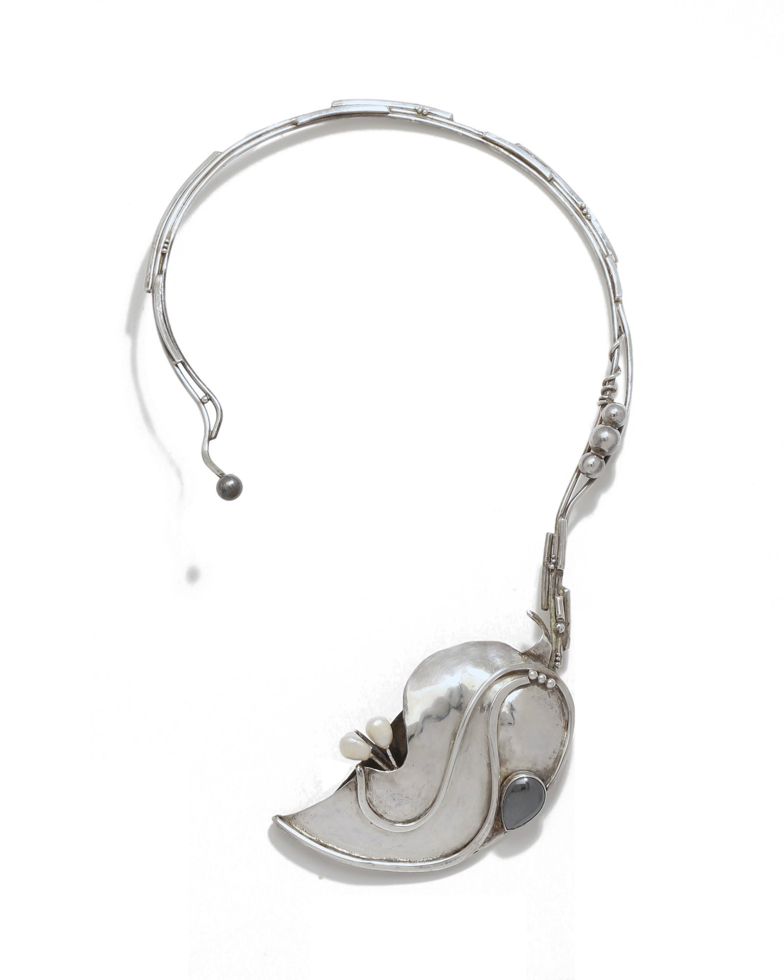A gem-set sterling silver collar necklace: Third quarter 20th century Signed: A. Idan / .925 The rigid collar suspending a stylized leaf pendant set with marcasite and freshwater pearls 9.25" H x 6" W 108.5 grams Provenance: The Coll