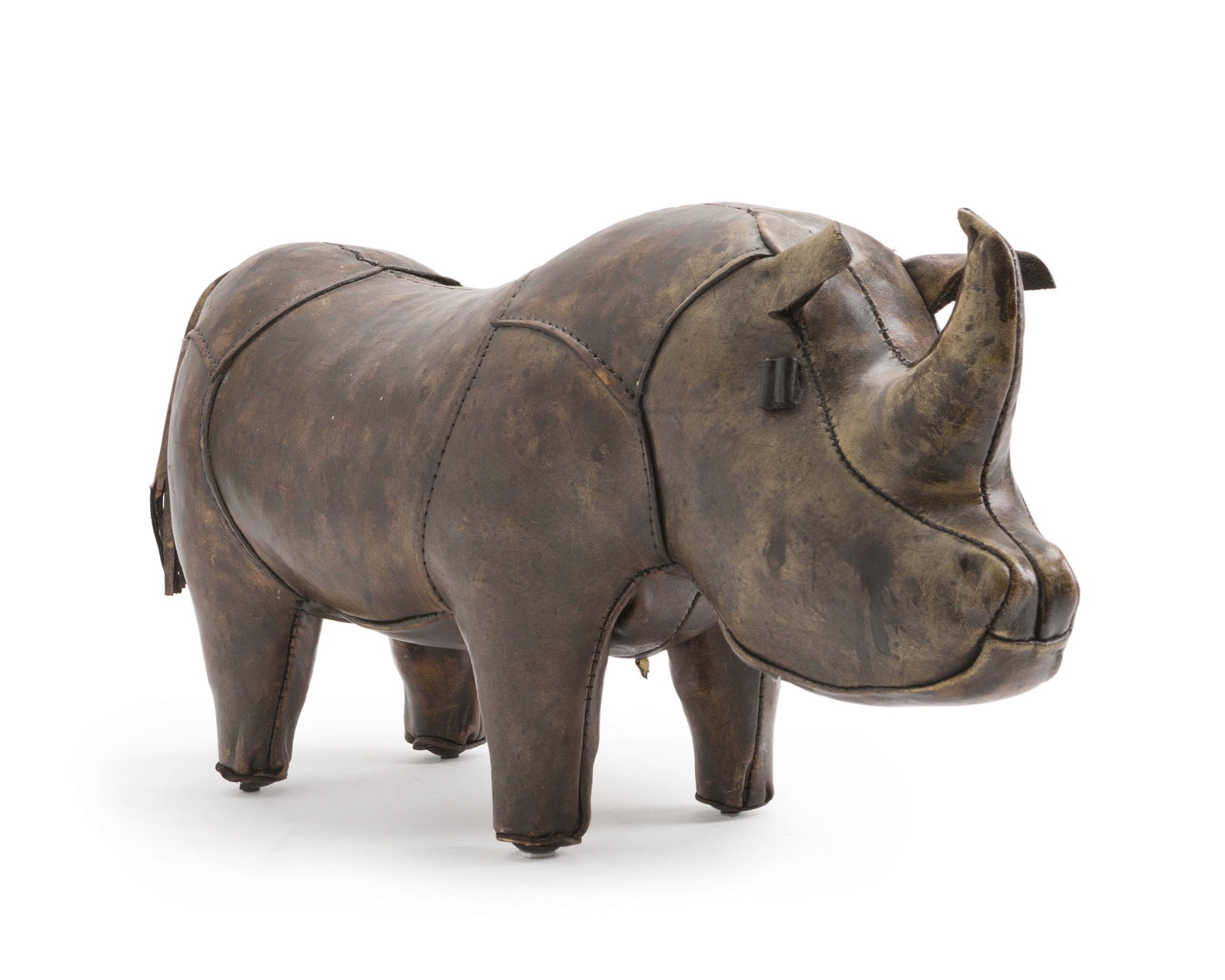 A Scully & Scully leather rhinoceros footstool: Fourth quarter 20th century Partial paper label: Made in England Stained brown leather 12" H x 24.5" W x 7.75" D