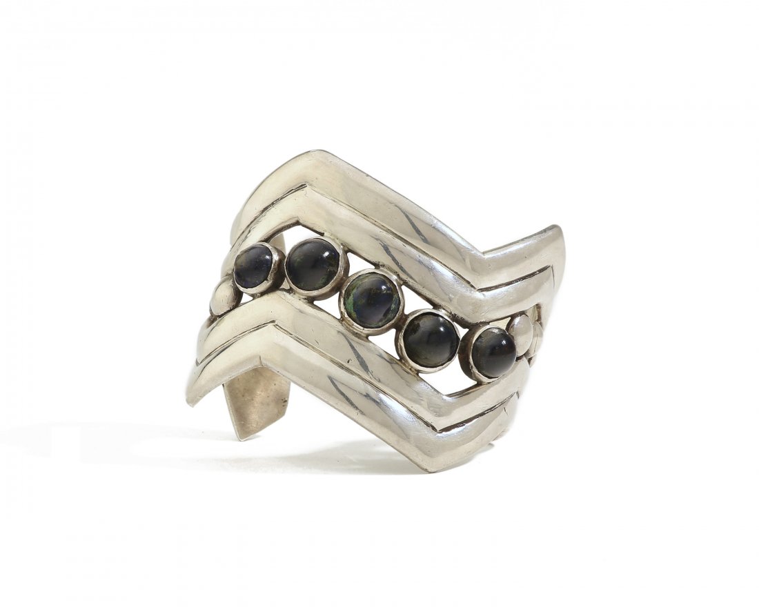 A William Spratling silver gem-set cuff bracelet: 1940-1946, First Design Period Stamped for William Spratling; Further stamped: Spratling Silver The zig-zig form cuff set with azurmalachite cabochons 2.25" H x 7.25" C; Wrist opening: 1.5" 151.5 gram