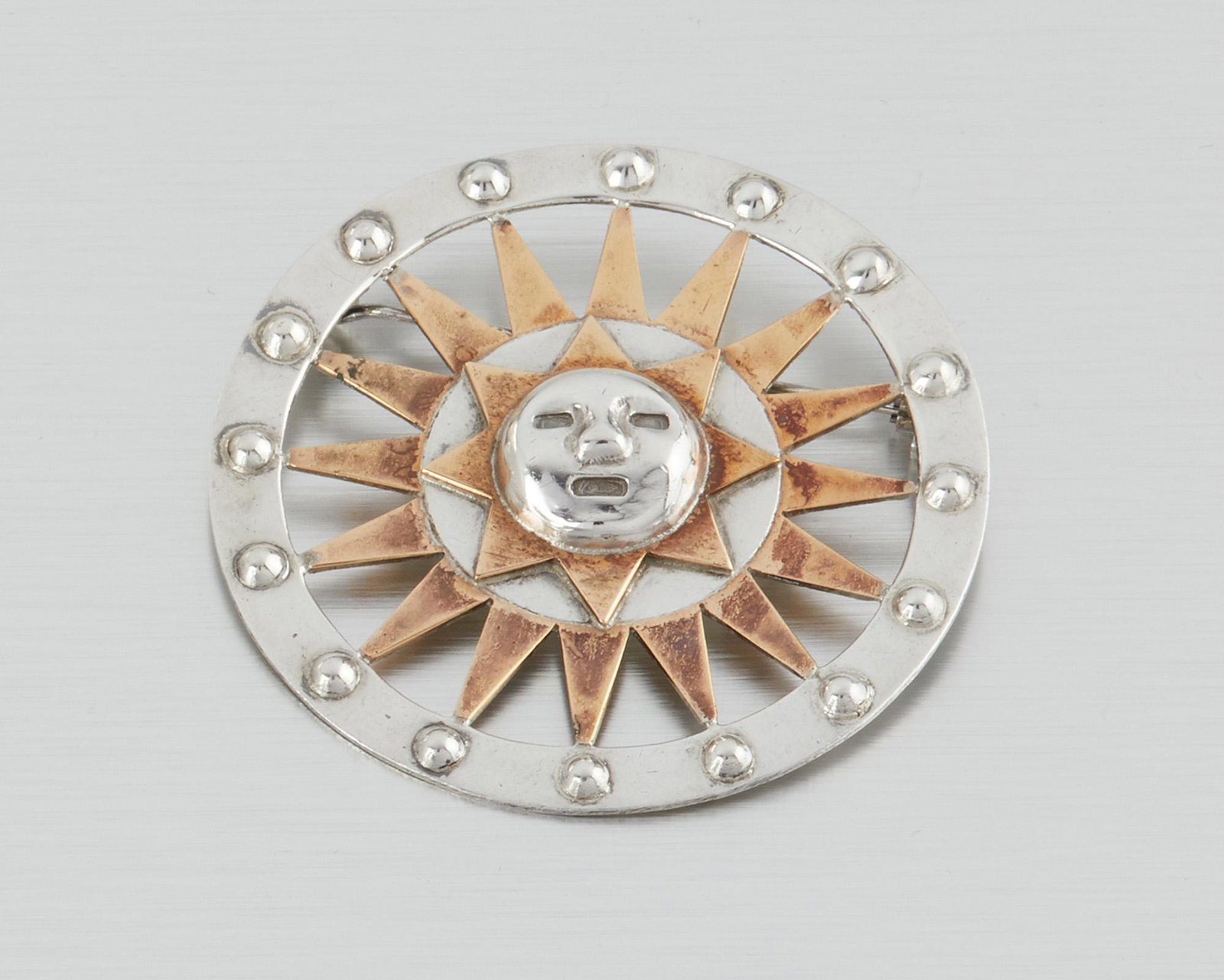 A William Spratling silver and copper brooch: 1940-1946; First Design Period; Taxco, Mexico Stamped for William Spratling; Further stamped: Made in Mexico / Silver The stylized Aztec sun-motif brooch with copper accents 2.325" Dia. 27.5 grams Pro