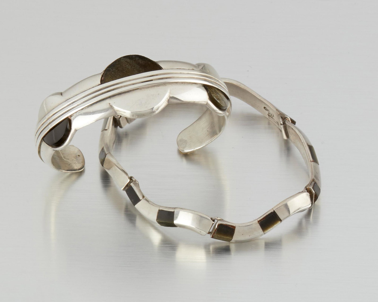 A pair of William Spratling sterling silver and: 1949-1956; Third Design Period; Taxco, Mexico Stamped for William Spratling; Further stamped: 925 / Spratling Comprising a triple-disk cuff bracelet inset with half-round obsidian together with a th