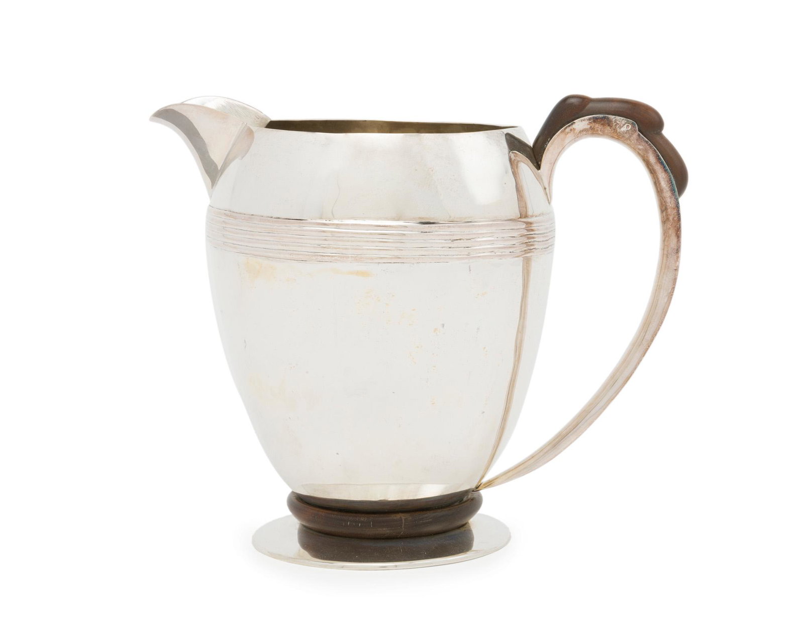 A William Spratling rosewood and sterling silver water: 1945-1946; First Design Period; Taxco, Mexico Stamped for William Spratling; Further stamped: Sterling The smooth-finish body with applied stripe design issuing a carved rosewood handle raised on a wi