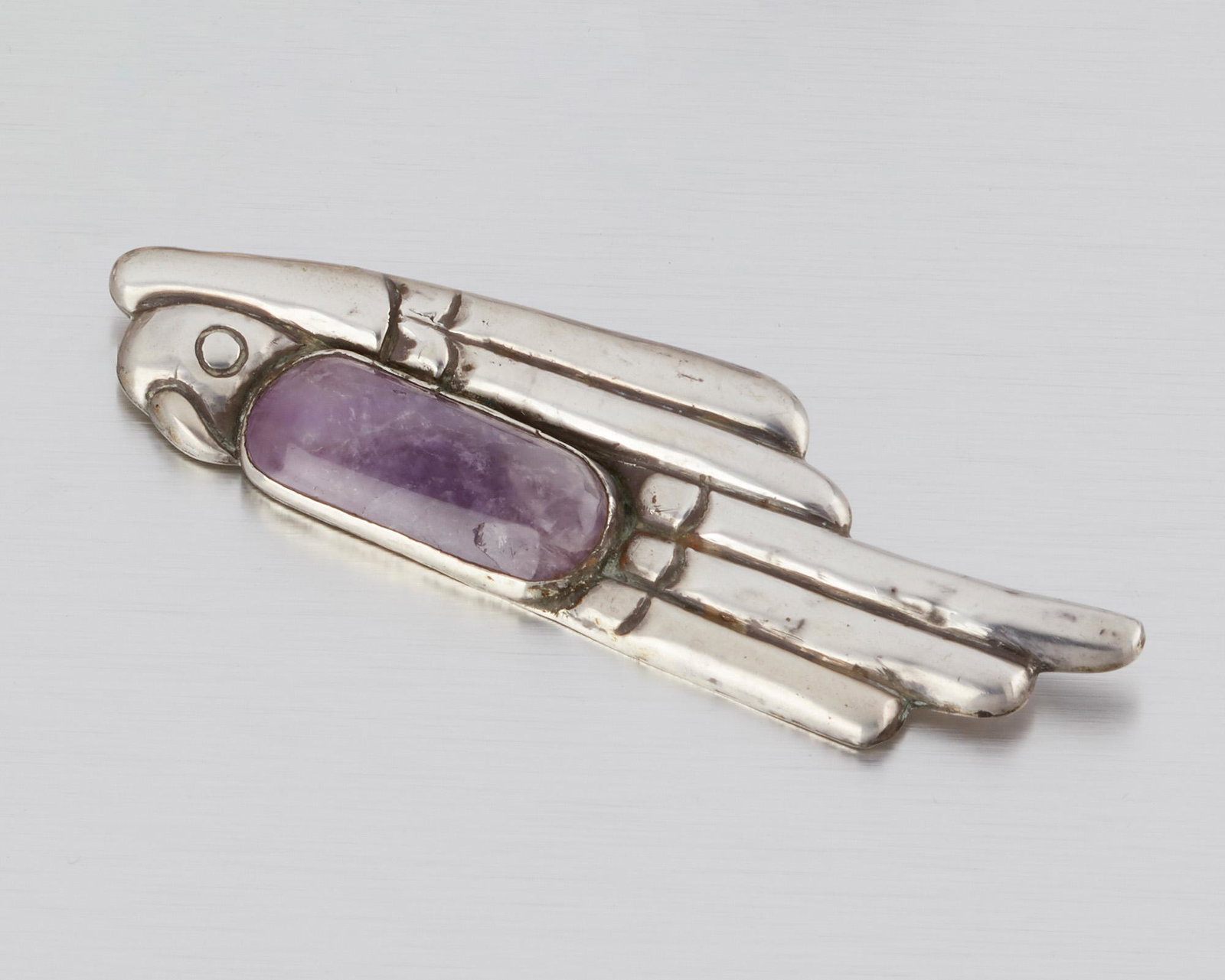 A William Spratling "Lorenzo" silver and amethyst: 1940-1946; First Design Period; Taxco, Mexico Stamped for William Spratling; Further stamped: Made in Mexico / Silver The stylized parrot brooch set with an amethyst cabochon, designed in honor of Spr