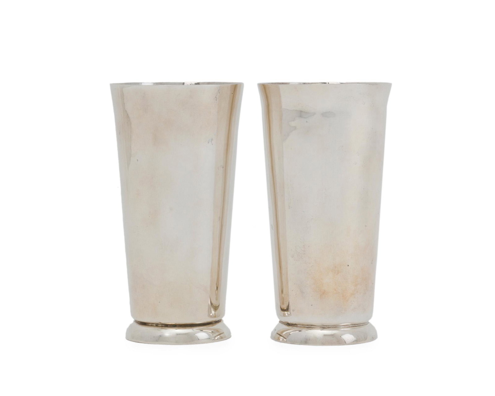 A pair of William Spratling sterling silver tumblers: 1944-1946; First Design Period; Taxco, Mexico Each stamped for William Spratling; Further stamped: Made in Mexico / Sterling Spratling referred to this design as a "heavy high cup for mint juleps," co