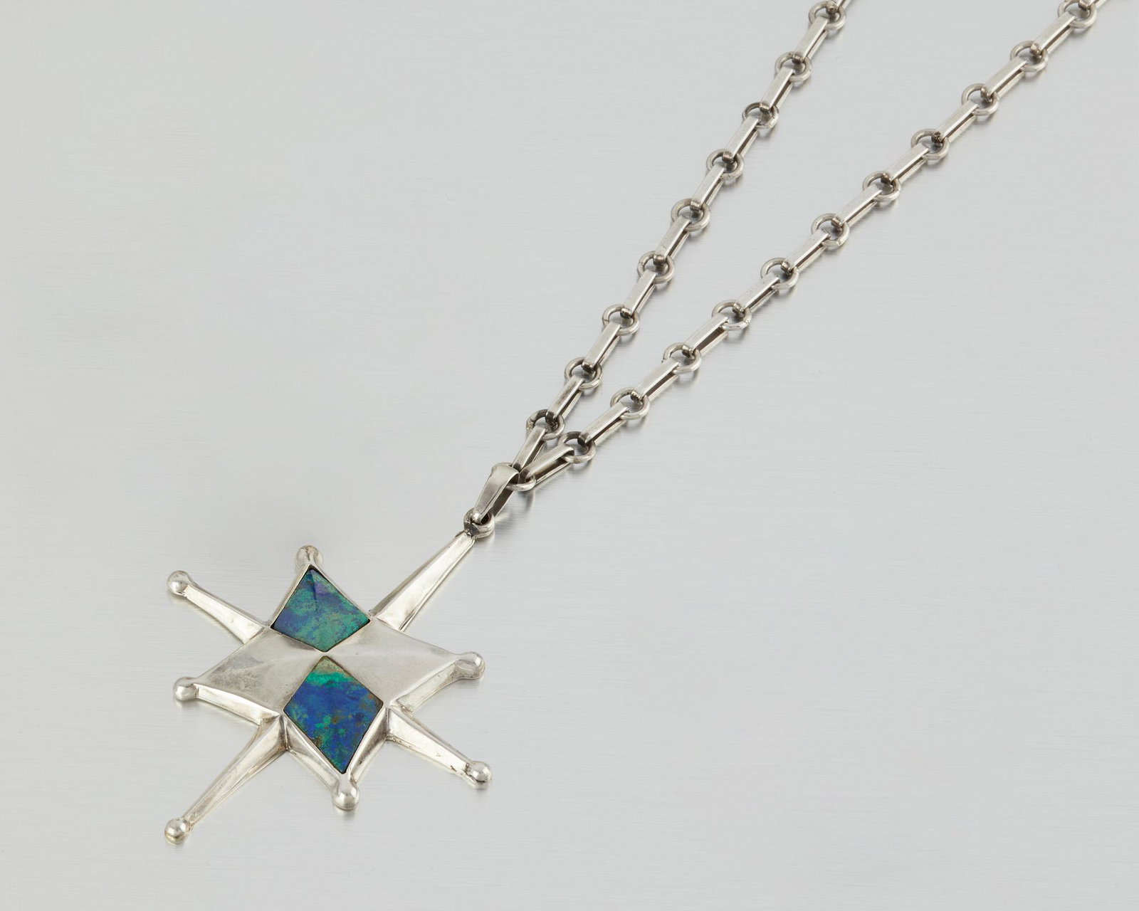 A William Spratling "Pendiente Estrella" necklace: 1949-1952; Second Design Period; Taxco, Mexico Stamped for William Spratling; Further stamped: Sterling / De Mexico / Eagle 13 Designed as a large North Star pendant with inlaid azurmalachite suspendi
