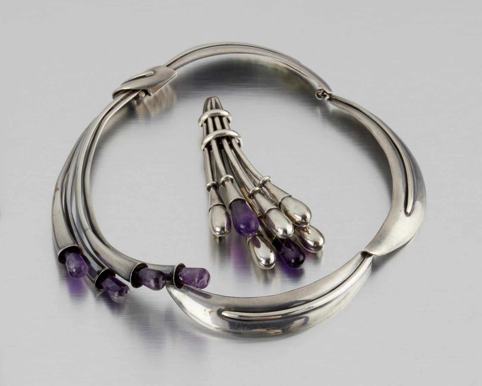 Two Antonio Pineda silver and amethyst jewelry items: 1953-1979 and 1941-1950; Taxco, Mexico Necklace: Crown mark for Antonio Pineda; Eagle 17; Further stamped: Hecho en Mexico / Silver / 970; Brooch stamped: AP for Antonio Pineda; Further stamped: Silve