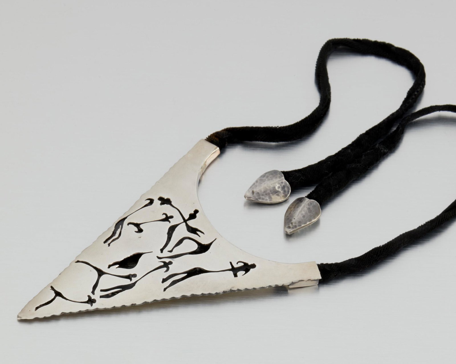 An Antonio Pineda silver Lascaux-motif necklace: 1953-1979; Taxco, Mexico Crown mark for Antonio Pineda; Indistinct Eagle; Further stamped: Silver / Hecho en Mexico / 970 / YY597 The arrowhead-form pendant designed with a Lascaux-inspired motif on a