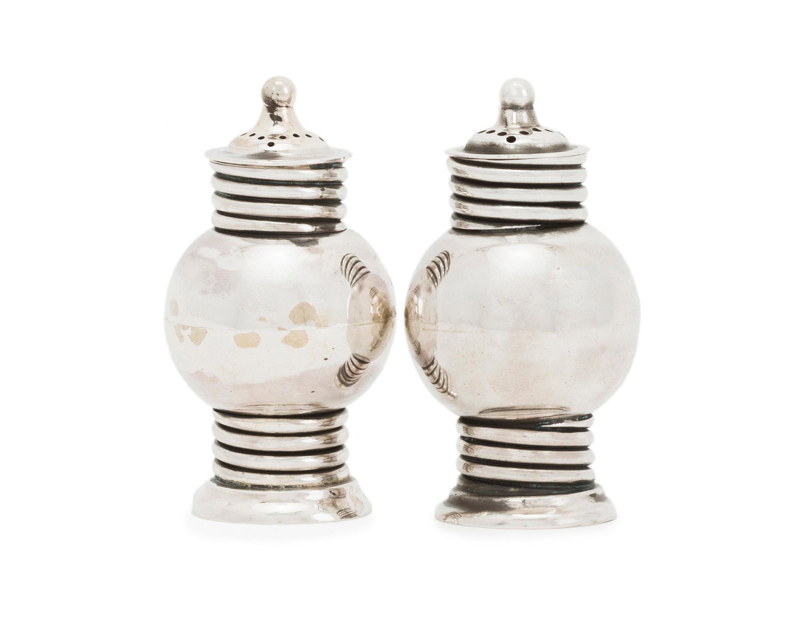 A set of William Spratling for Conquistador salt and: 1949-1951; Second Design Period; Taxco, Mexico Stamped: Spratling de Mexico / Sterling / Eagle 13; Further stamped for Conquistador Each sphere-form shaker with ribbed accents topped with a ball finia
