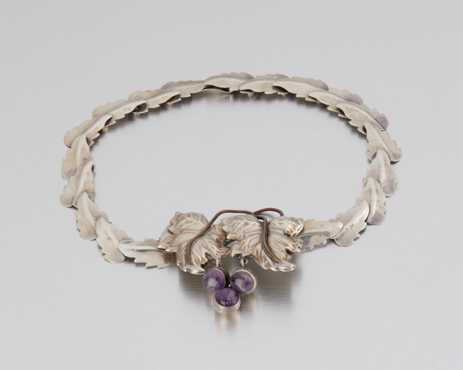 A Fred Davis silver, copper and amethyst necklace: Second quarter 20th century; Mexico City, Mexico Stamped: FD for Fred Davis; Made in Mexico / Silver Designed as an intertwined grape leaf-motif suspending a cluster of three amethyst cabochons with a
