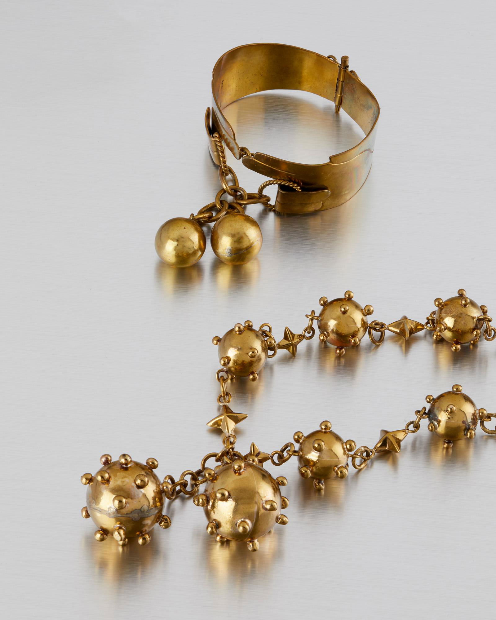 Two Hubert Harmon mixed-metal jewelry items: 1942-1948; Taxco, Mexico Stamped for Hubert Harmon; Further stamped: Mexico Comprising a brass-colored stylized bomb necklace together with a hinged bangle with spherical drops, 2 pieces Necklace: