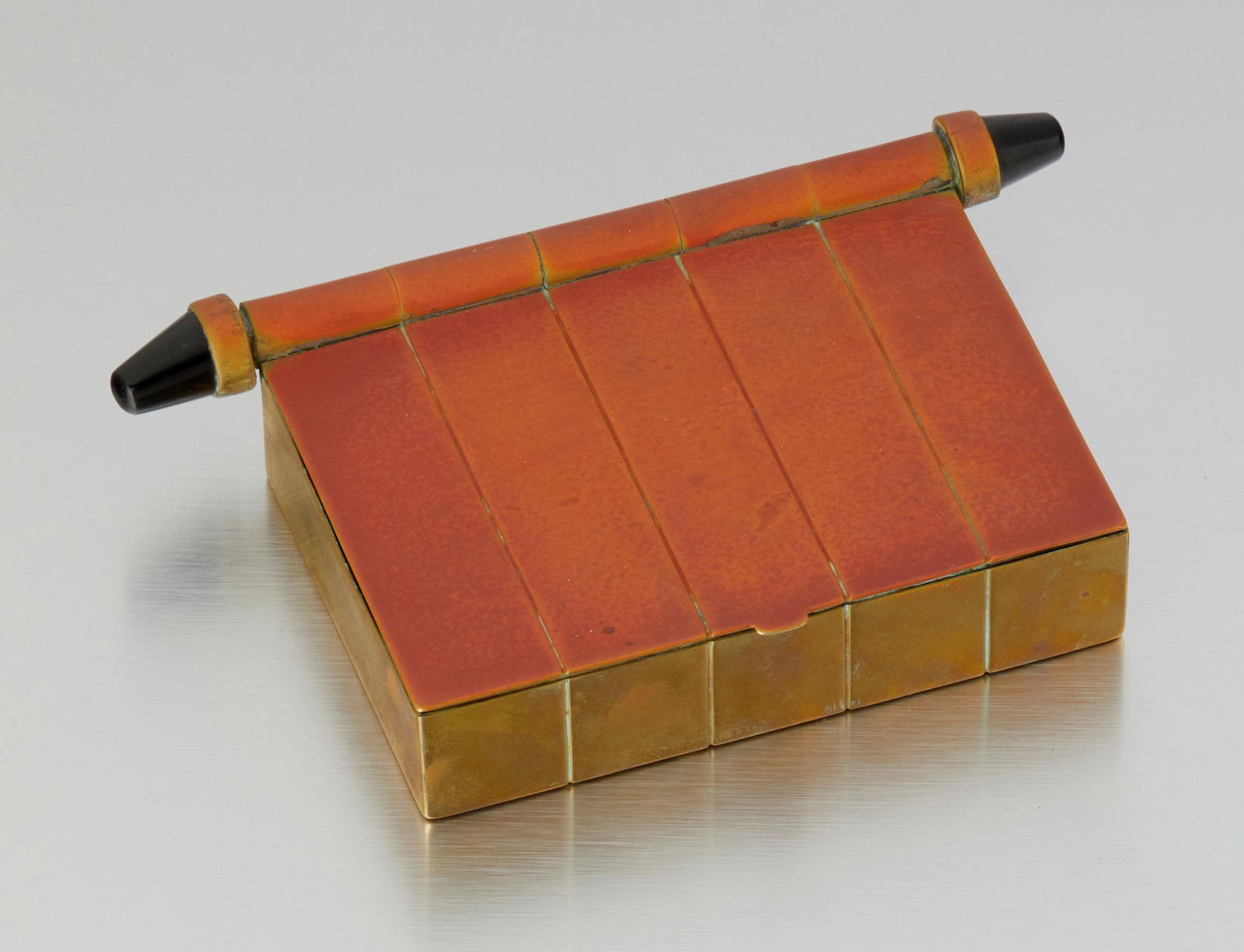 A Hubert Harmon brass and obsidian box: 1942-1948; Taxco, Mexico Stamped: Hubert Harmon; Further stamped: Mexico The brass box with oxidized top and cylindrical obsidian detailing 1.5" H x 7" W x 4" D 397.0 grams Provenance: The Colle