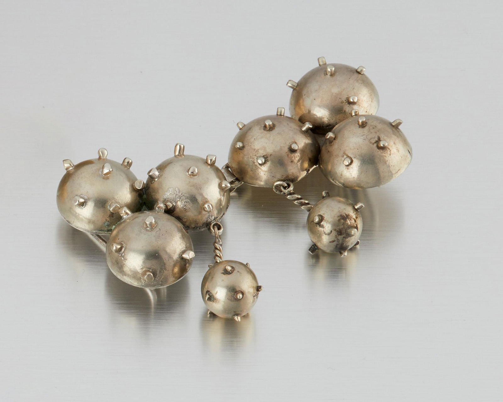 A Hubert Harmon sterling silver belt buckle: 1944-1948; Taxco, Mexico Winged feet for Hubert Harmon; Further stamped: Made in Mexico / Sterling Designed with whimsical stylized bombs 4.5" W x 3.75" H 100.0 grams Provenance: The Collection